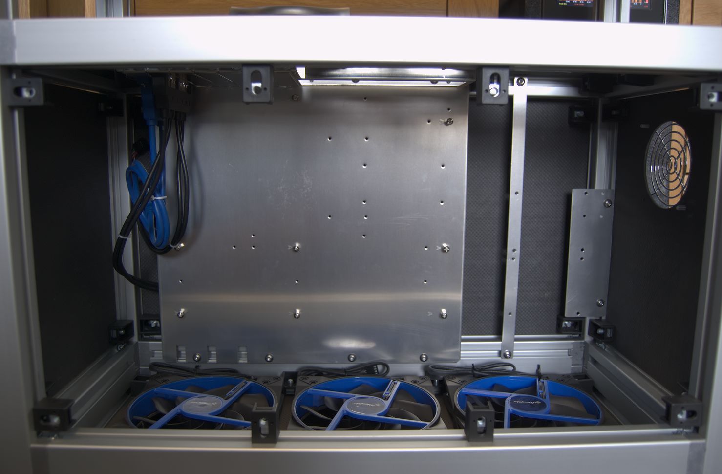 Inside the case, showing the motherboard tray at the back, and the three large fans along the bottom.